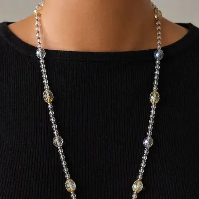 Sautoir fin et délicat, composé de perles cristal et de perles de rocailles argentées aux reflets subtils.